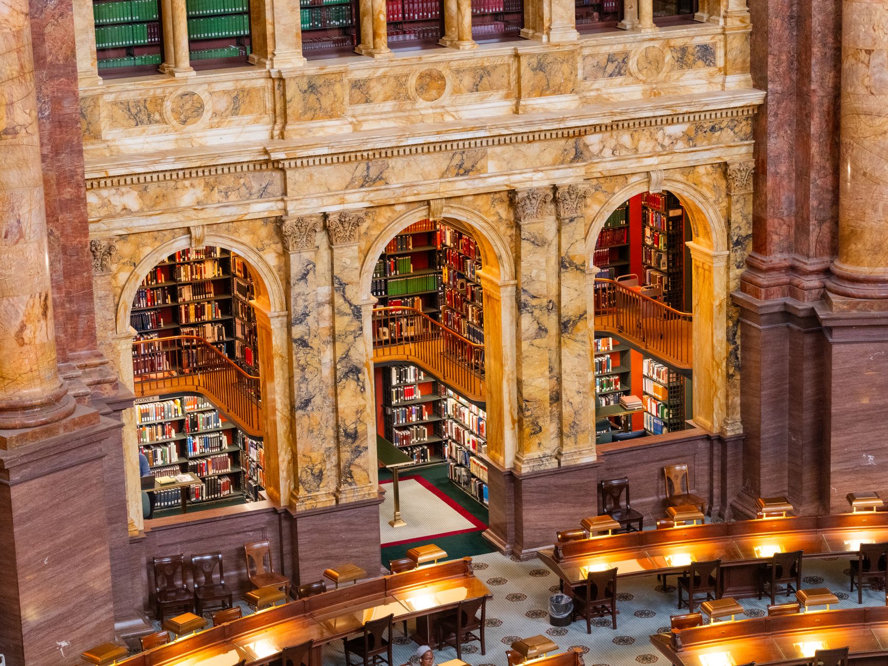 The ornate marble reading room of a great law library, with tiered bookshelves and reading desks